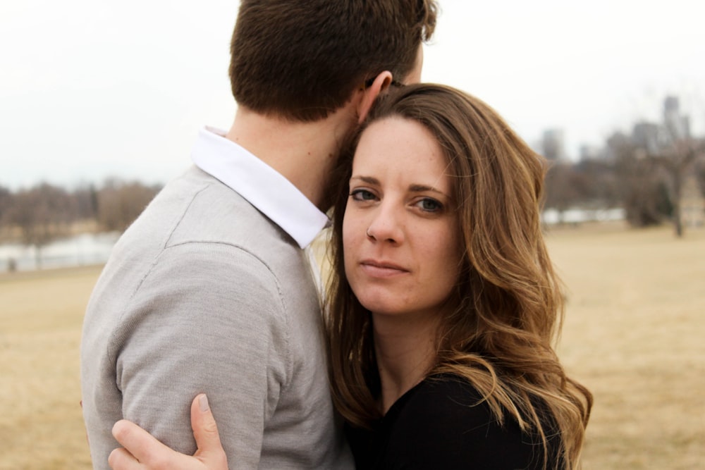 man in grey and white collared shirt and woman in black top