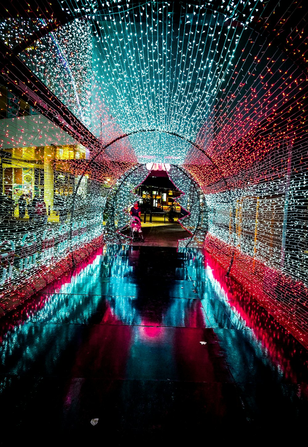 red and teal string lights tunnel