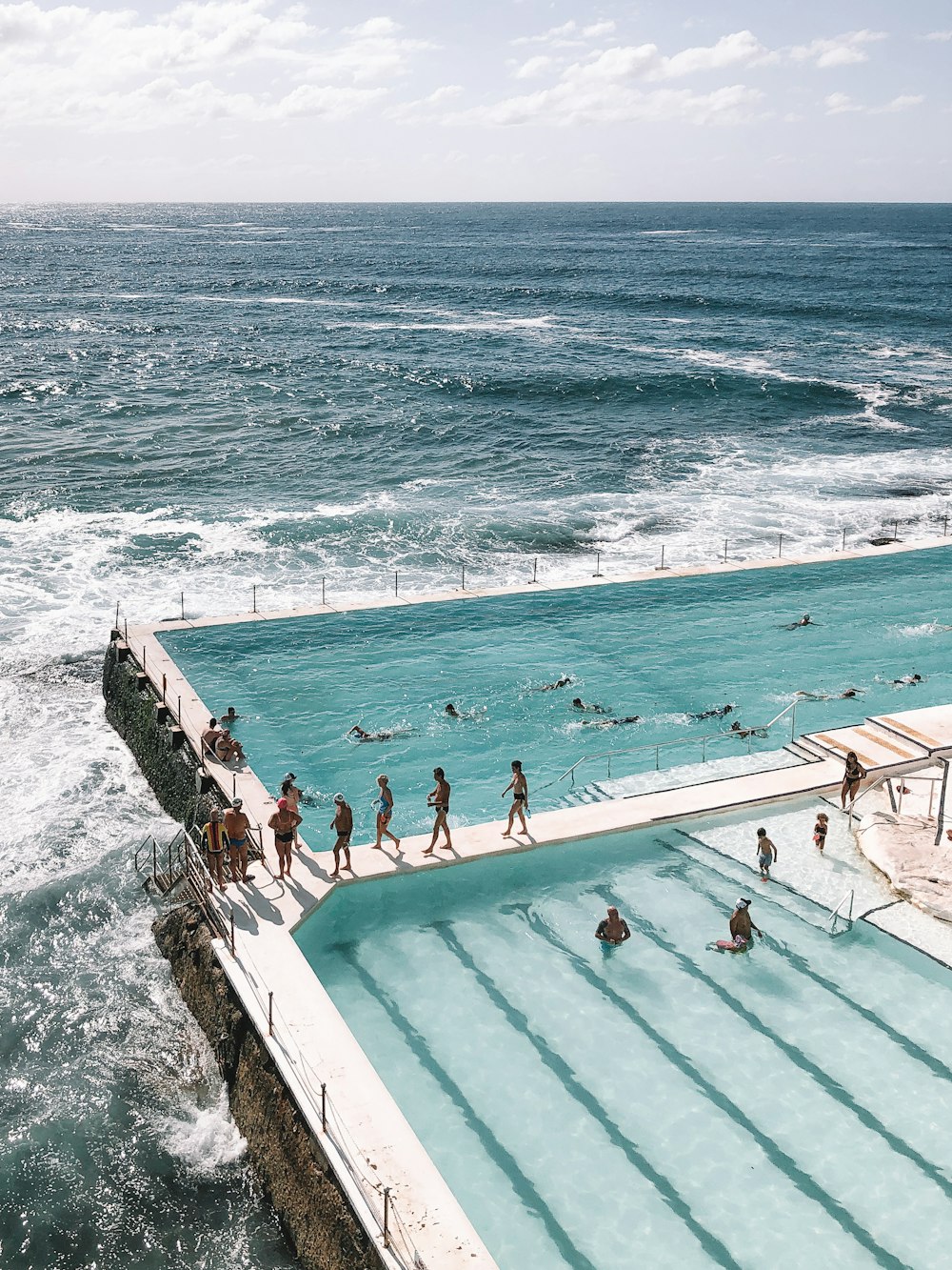 people swimming on pool near sea