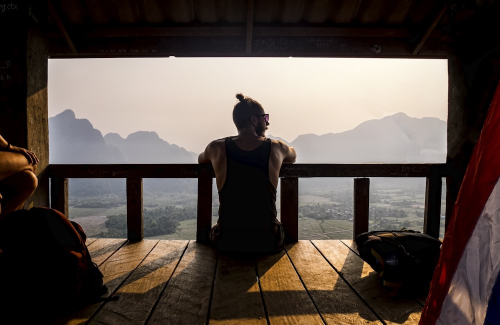 topless man sitting on wooden floor