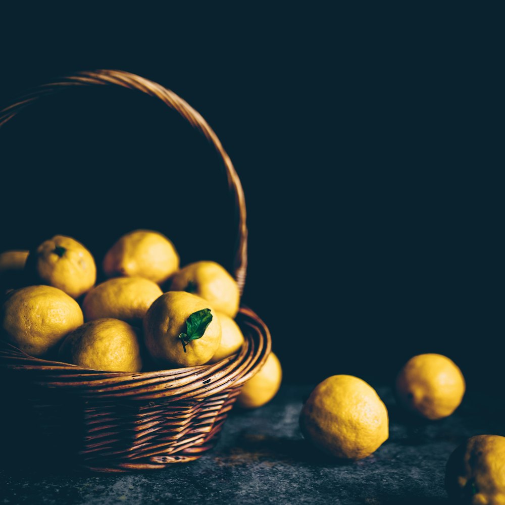 limones amarillos en una canasta de mimbre marrón