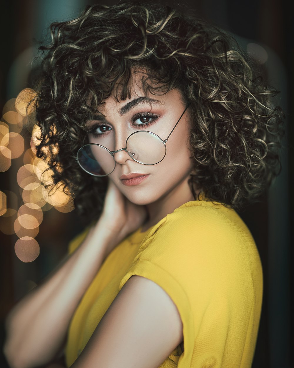 woman wearing hippie eyeglasses with bokeh lights