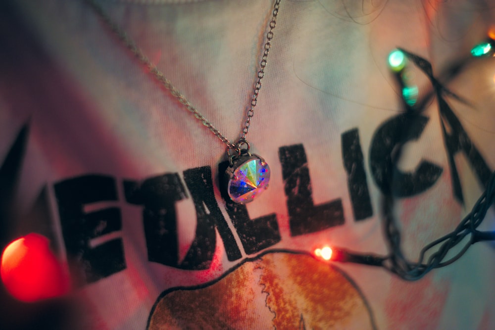 Metallica-prinetd shirt and iridescent pendant necklace