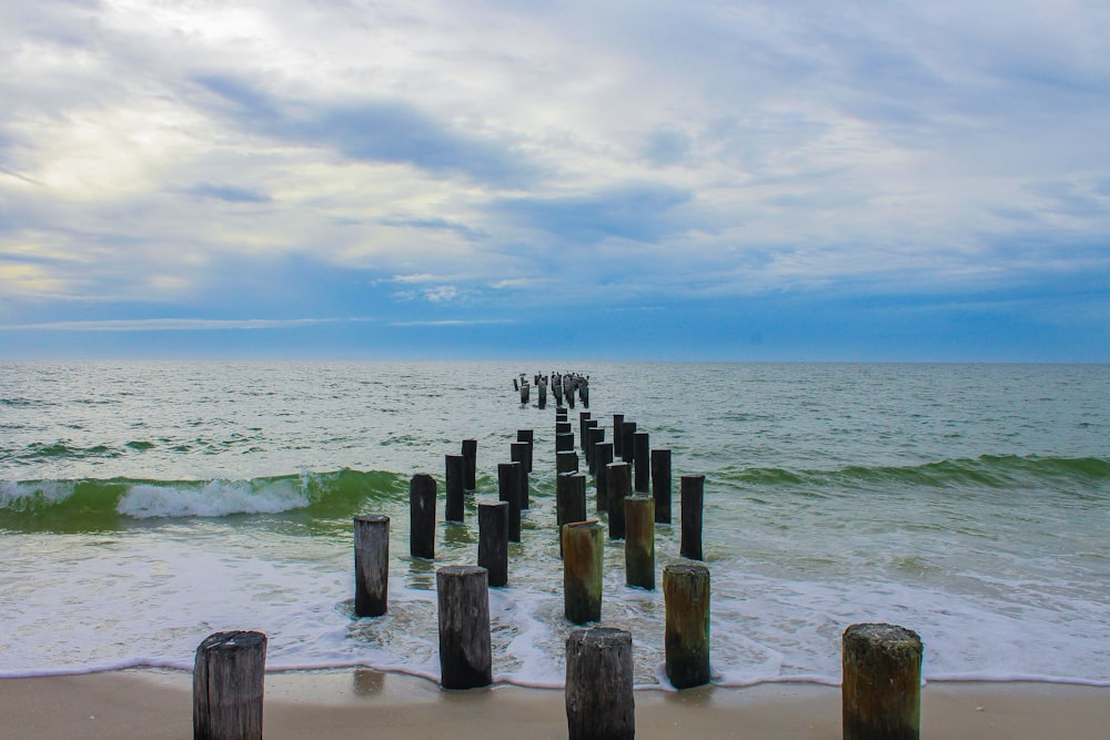 a long wooden pier sitting on top of a sandy beach