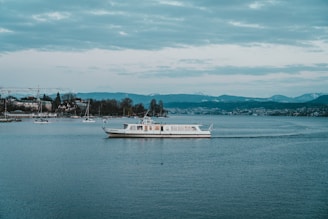 white boat on calm sea under white sky during day time