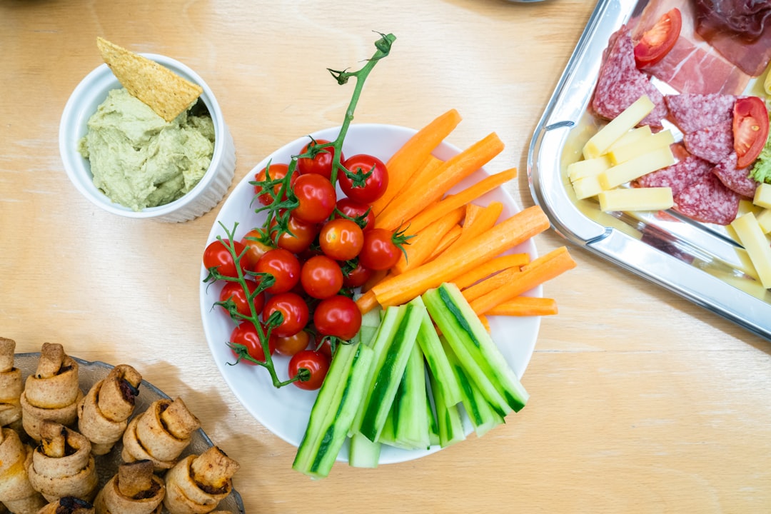 slices of carrots, zucchini, and cherry tomatoes on round white ceramic bowl