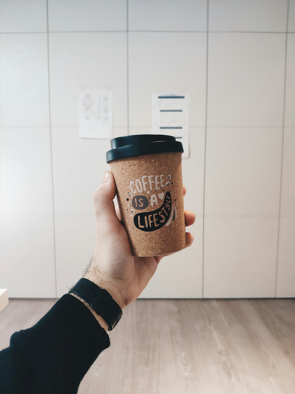 brown and black coffee cup with lid