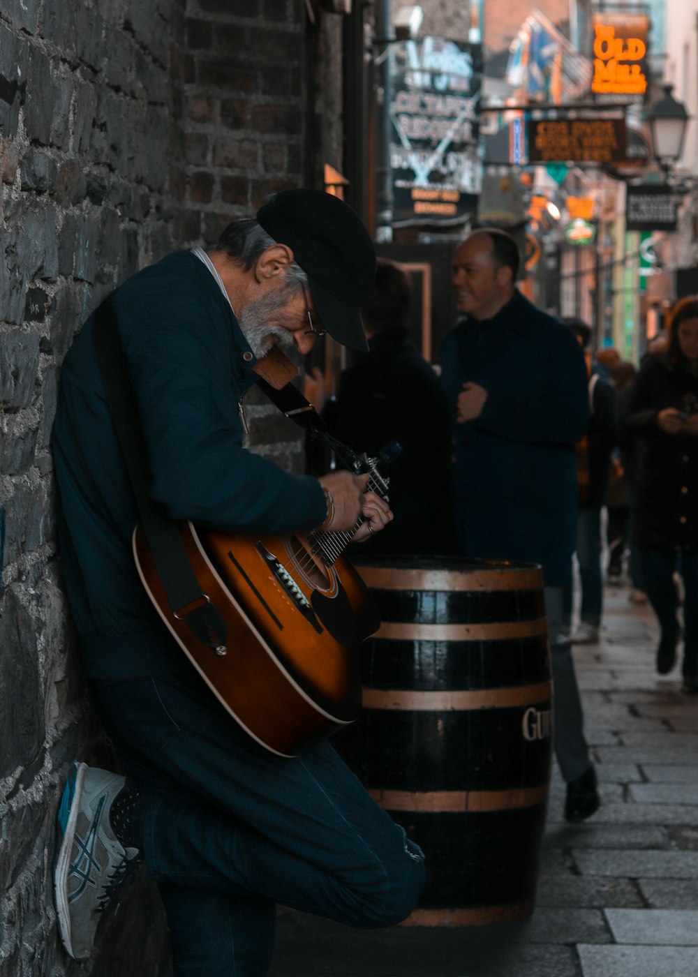 man playing guitar on street