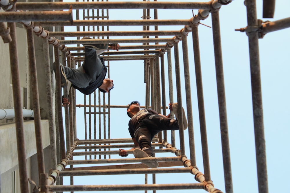 two men on brown metal pipes