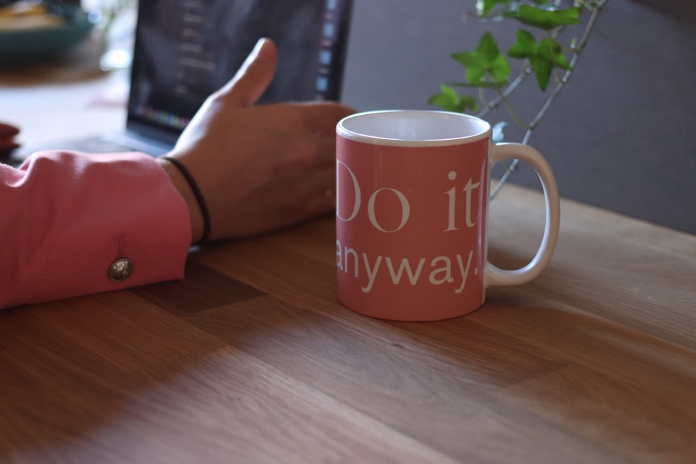 pink and white ceramic mug on table