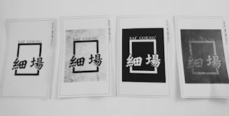 Four printed papers are arranged in a row, each displaying a rectangular design with the text 'SAI' 'COENG' at the top and Chinese characters below. The appearance of each sheet varies, with different levels of contrast and background patterns.