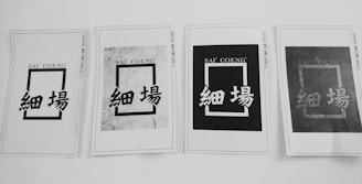 Four printed papers are arranged in a row, each displaying a rectangular design with the text 'SAI' 'COENG' at the top and Chinese characters below. The appearance of each sheet varies, with different levels of contrast and background patterns.