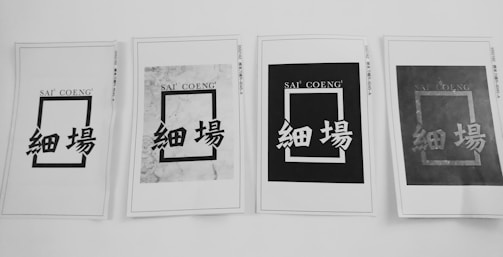 Four printed papers are arranged in a row, each displaying a rectangular design with the text 'SAI' 'COENG' at the top and Chinese characters below. The appearance of each sheet varies, with different levels of contrast and background patterns.