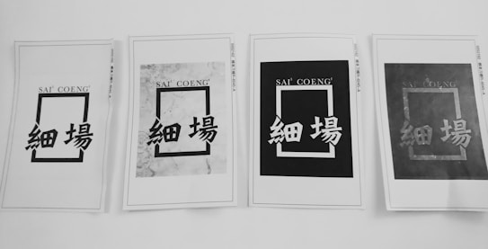 Four printed papers are arranged in a row, each displaying a rectangular design with the text 'SAI' 'COENG' at the top and Chinese characters below. The appearance of each sheet varies, with different levels of contrast and background patterns.