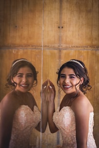 A young woman smiling confidently with elegant prom makeup and styled hair.