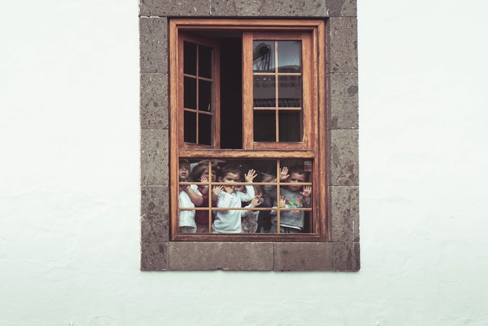 kids behind the window of building