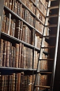 A close-up of a ladder shelf showcasing its rich wood grain and neatly arranged books.
