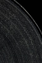 Vinyl record surface with glitchy neon cracks glowing against a black void.