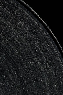 Vinyl record surface with glitchy neon cracks glowing against a black void.