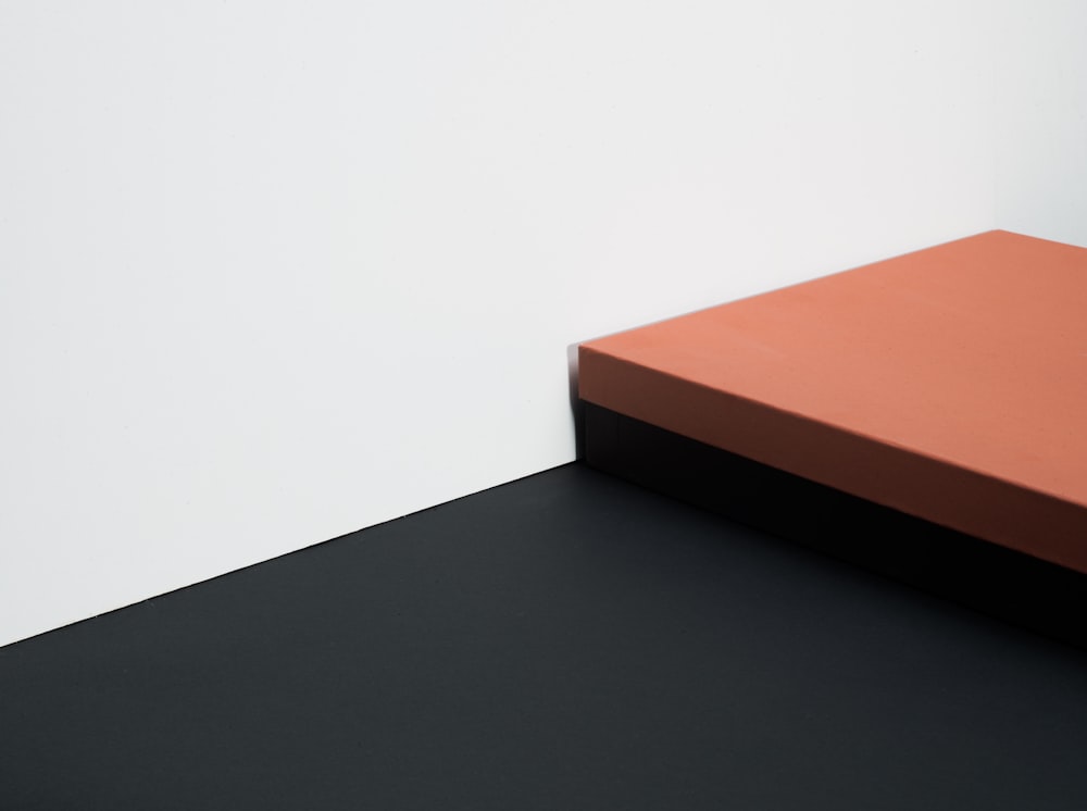 uma caixa laranja e preta sentada em cima de uma mesa preta