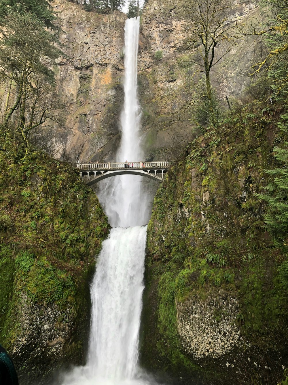 waterfalls front of bridge at daytime