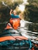 selective focus photography of woman riding kayak holding oar during daytime