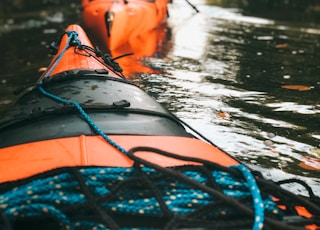 selective focus photography of woman riding kayak holding oar during daytime