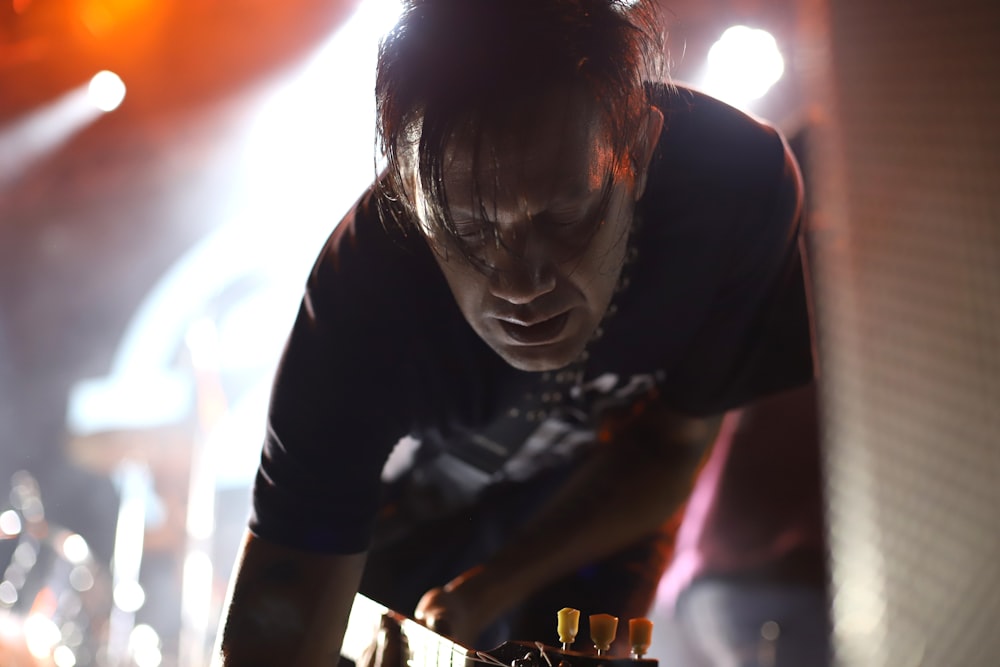 man wearing black shirt while playing guitar