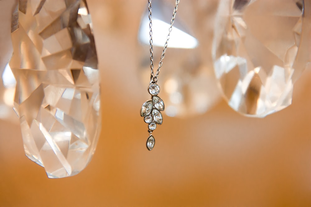silver-colored diamond pendant necklace