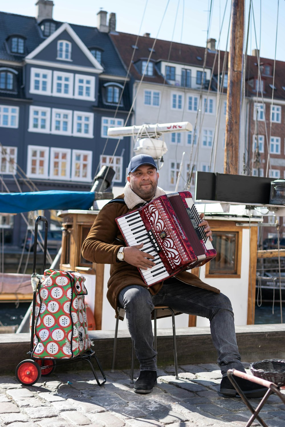 man sitting on chair playing harmonium