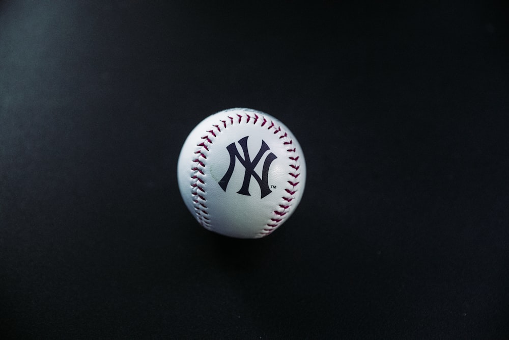 white and red New York Yankees baseball on black surface
