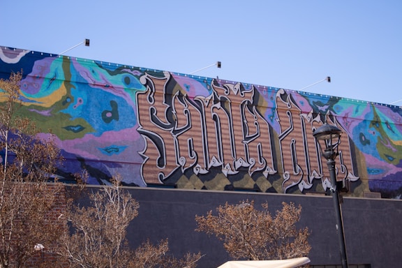 A vibrant mural showcasing bilingual text and graffiti art.