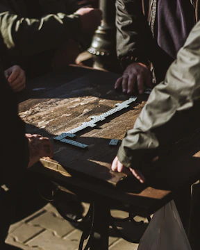 Photo of a tense dominoes match with players focused around the table.