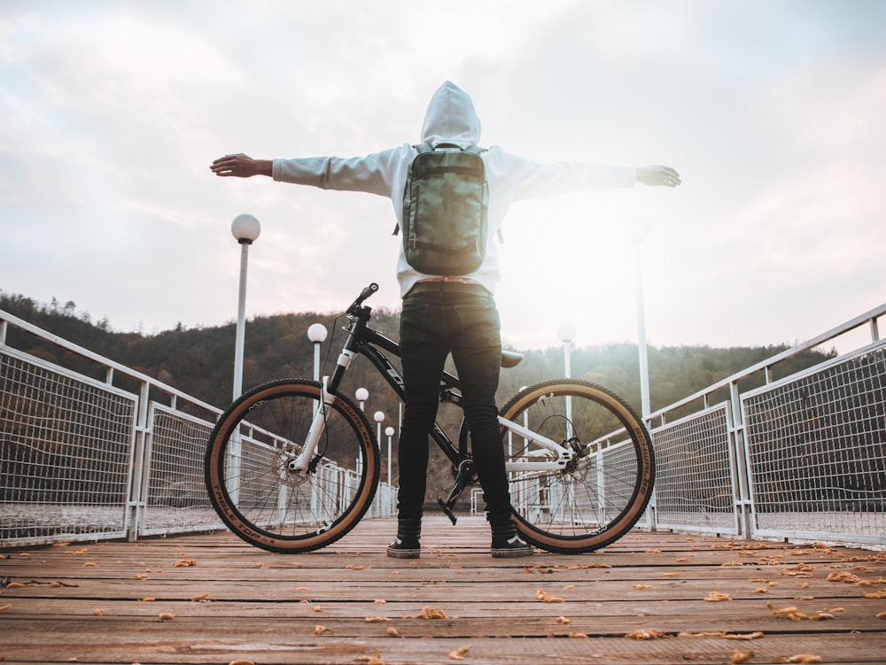 man standing in front of black hardtail bicycle