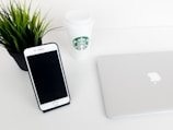 A minimalist desk setup with a plant and a cup of coffee.