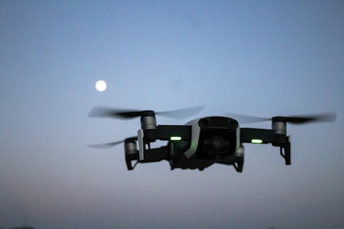 Drone flying over a river border monitoring area at dusk.