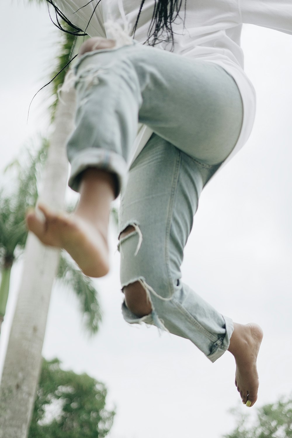 woman jumping near gray pole