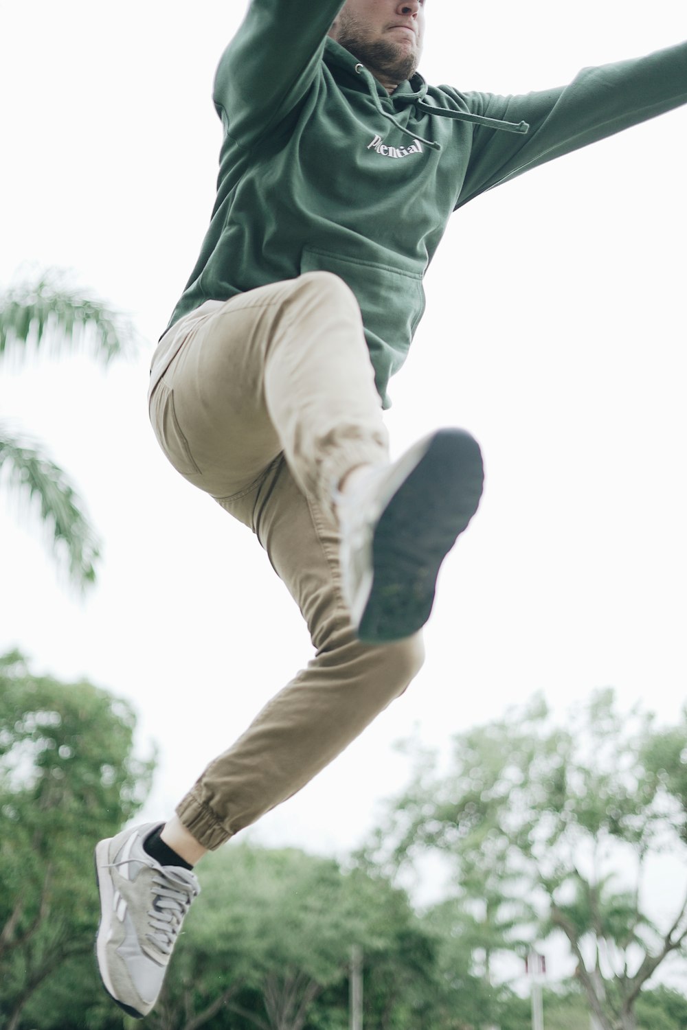 man jumping near tree