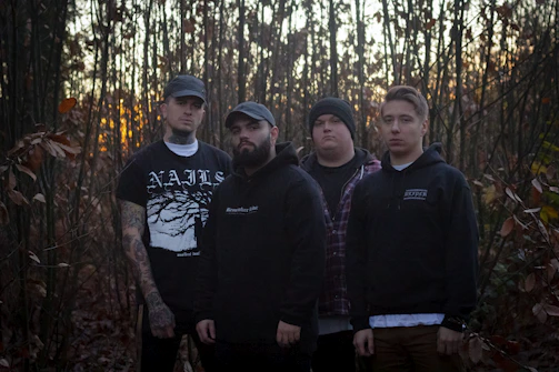 A group of fathers walking together at dawn, united in faith and purpose along a wooded path.