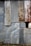 An assortment of corrugated metal sheets, weathered and rusted, are patched together to form a wall. The surface features a mix of textures and hues, with visible signs of aging and corrosion.