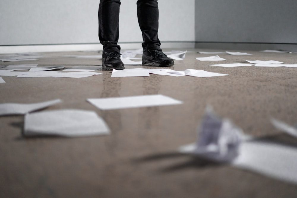 person standing near papers on ground