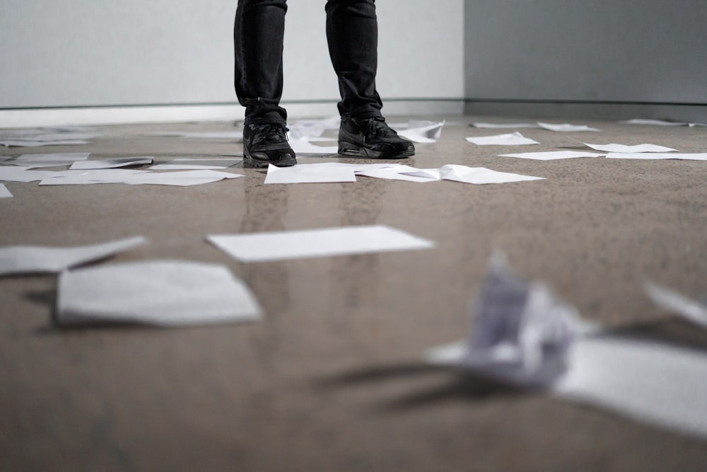 Persona parada cerca de papeles en el suelo