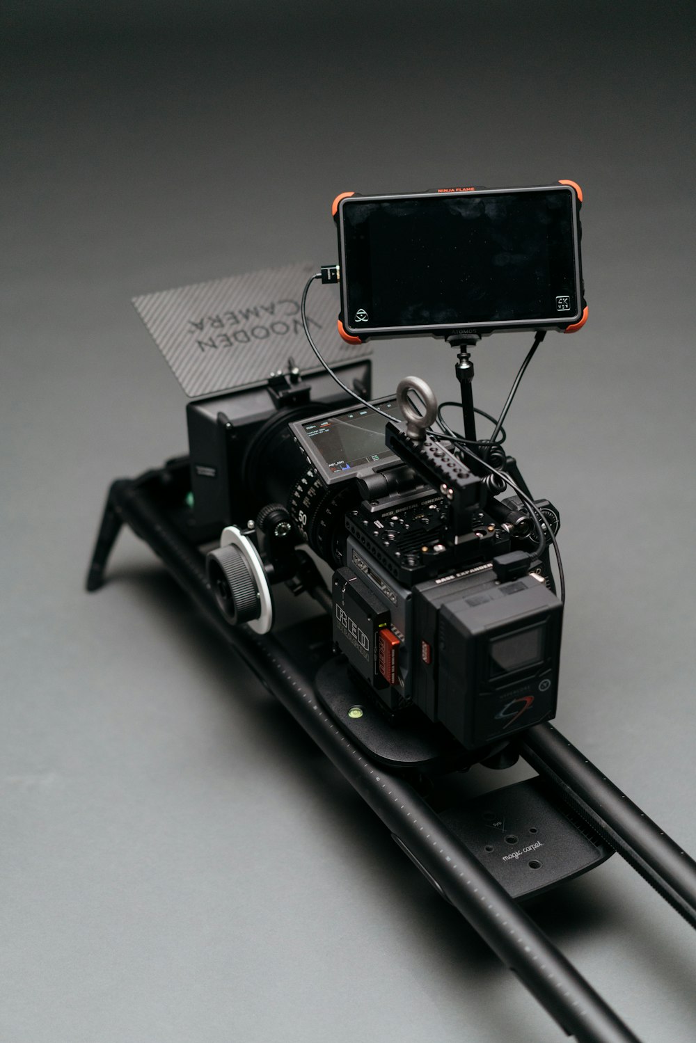レール上のカメラに取り付けられた黒いフラットスクリーンモニター