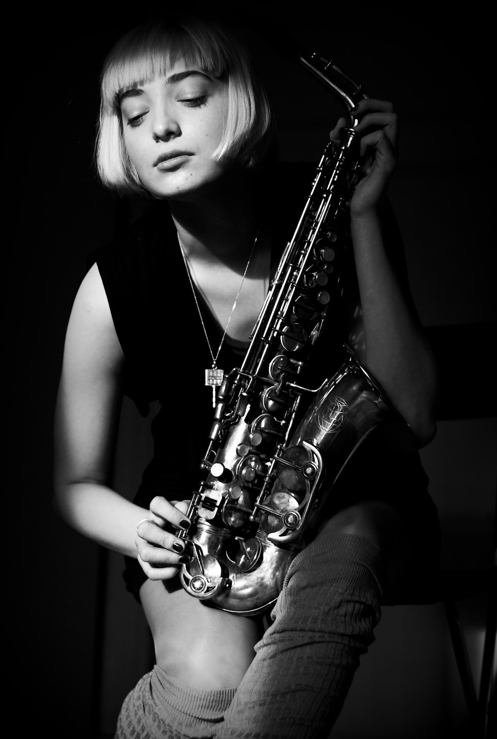 grayscale photography of woman holding saxophone