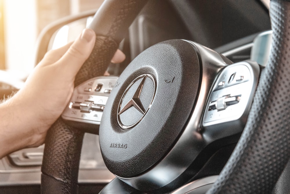 personne tenant le volant multifonction Mercedes-Benz