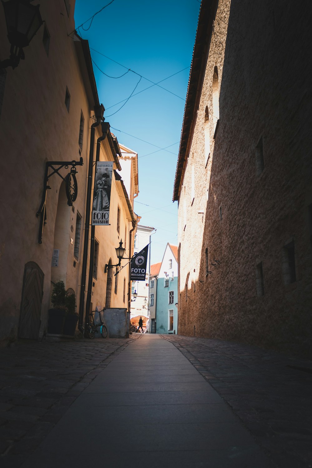 a narrow street with a sign on the side of it