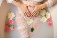 woman touching her belly in bathtub