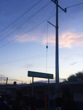 Close-up of hands shaking in front of the Querétaro cityscape at sunset.