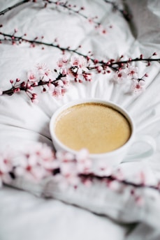 A cozy street café in Tokyo with cherry blossoms gently falling around a couple enjoying coffee.