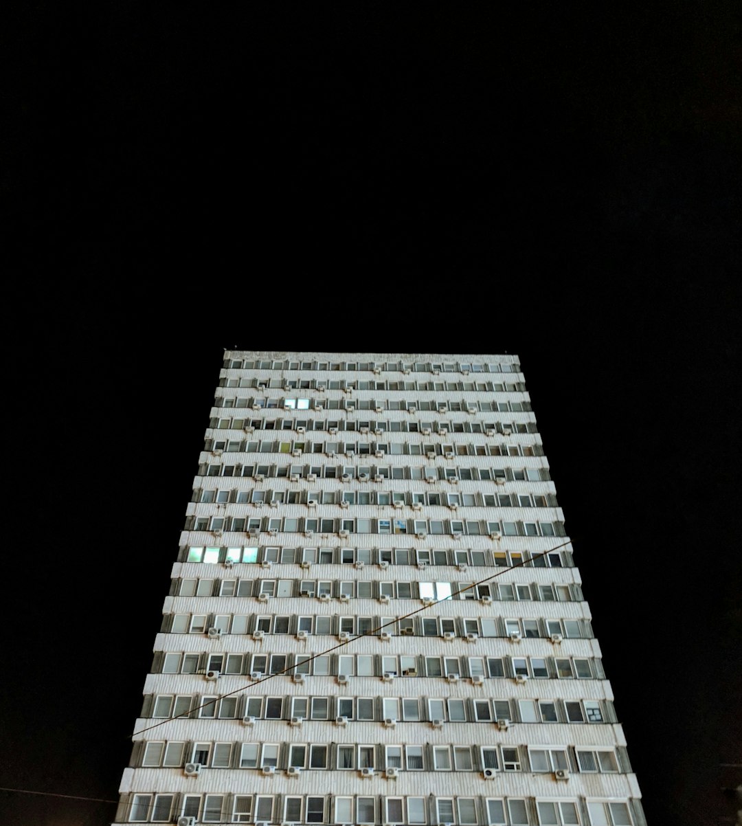low-angle photography of white concrete building at night